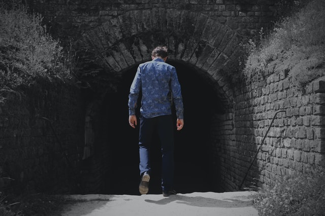 man walking into a tunnel