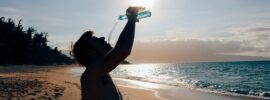 man drinking water in a beach