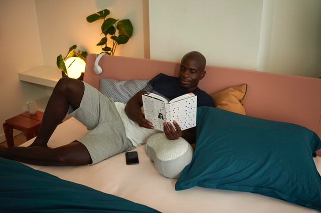 man reading at night on his bed